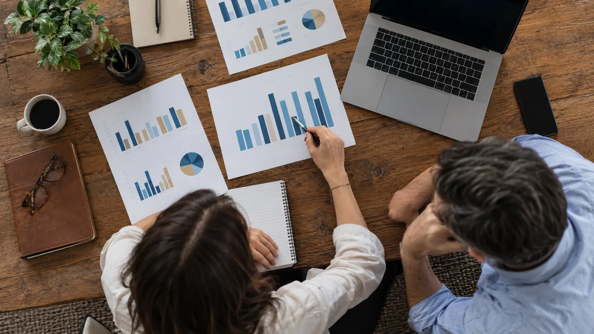 Analyse croisée de rapports imprimés et de graphiques sur un ordinateur.